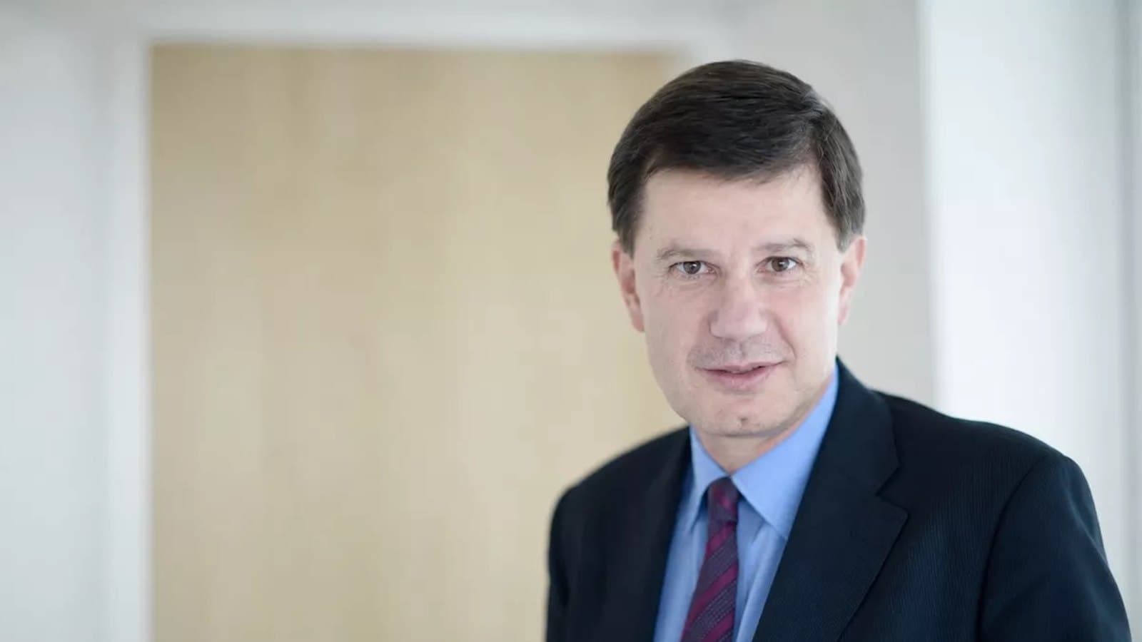 A portrait of Benoit de Juvigny in a suit and tie.