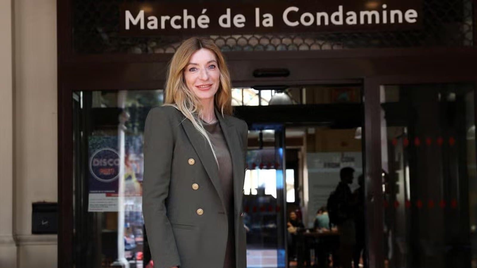 Marjorie Crovetto standing in front of the Marche de la Condamine entrance in Monaco.