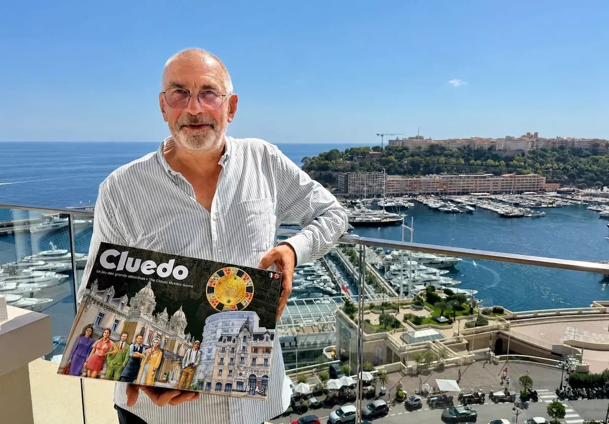 Jean-Benoît Héron pose avec la boîte du Cluedo monégasque sur un balcon dominant Monte-Carlo