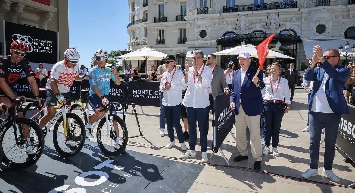 Le prince Albert II agite un drapeau rouge au départ d'une sortie cycliste caritative place du Casino à Monaco