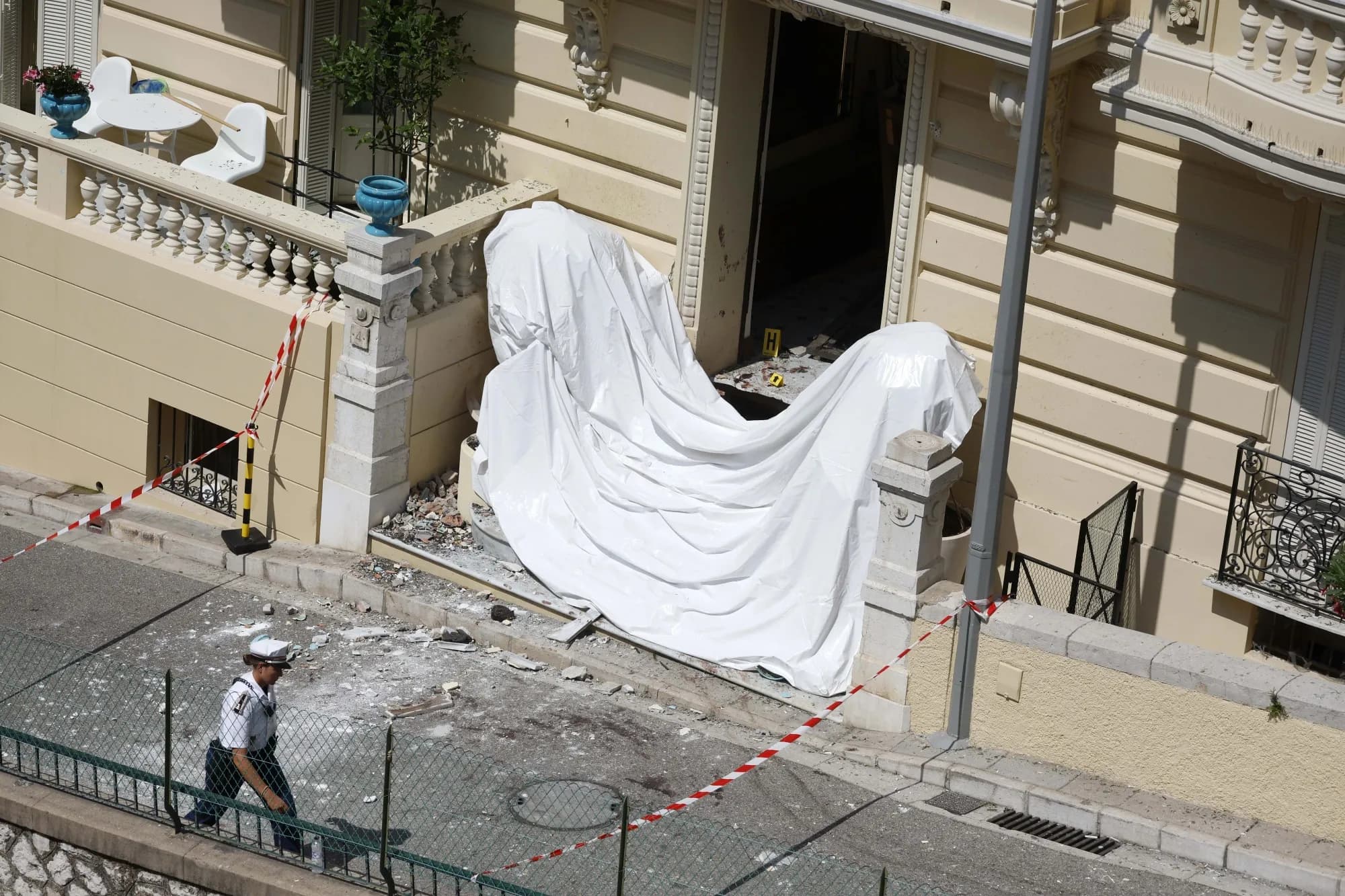 Police tape and a covered blast site outside a Monaco apartment building after a bomb attack